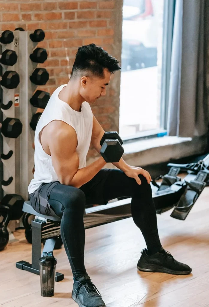 Persona entrenando fuerza con mancuernas en un gimnasio
